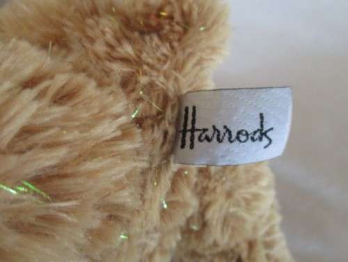 A PRETTY HARRODS BEAR WITH TINSEL IN HIS FUR