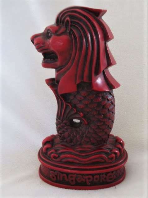 A SOLID RED RESIN PAPERWEIGHT FIGURINE OF SINGAPORE'S MYTHICAL MERLION