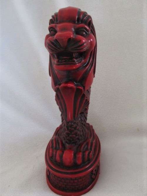 A SOLID RED RESIN PAPERWEIGHT FIGURINE OF SINGAPORE'S MYTHICAL MERLION