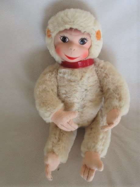 A VINTAGE 1950's/60's FULLY JOINTED MOHAIR RUBBER-FACED SCHUCO MONKEY WITH FELT EARS AND SQUEAKER