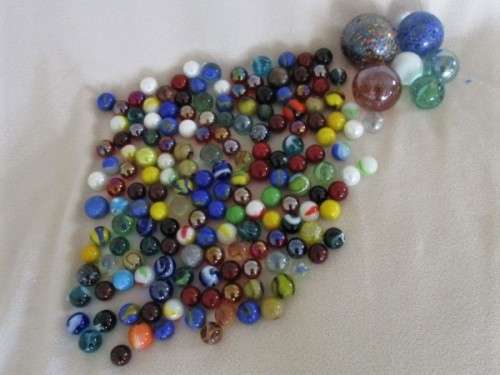 A DENIM DRAWSTRING BAG CONTAINING 160 GOOD QUALITY MARBLES PLUS 6 SHOOTERS IN VARIOUS SIZES