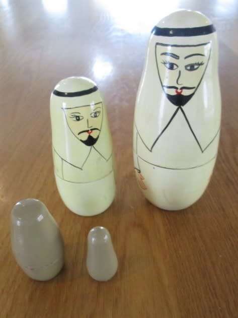 AN UNUSUAL FOUR PIECE HAND PAINTED MATRYOSHKA/BABUSHKA NESTING DOLL SET