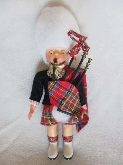 A SMALL VINTAGE SCOTTISH BAGPIPE PLAYER
