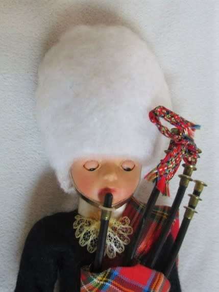 A SMALL VINTAGE SCOTTISH BAGPIPE PLAYER