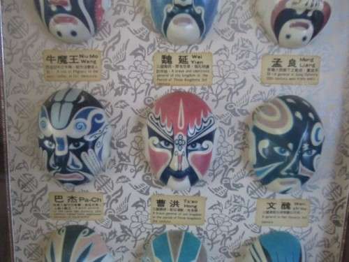 A VINTAGE BOXED FRAME DEPICTING VARIOUS FACIAL MASKS/CHARACTERS IN CHINESE OPERA