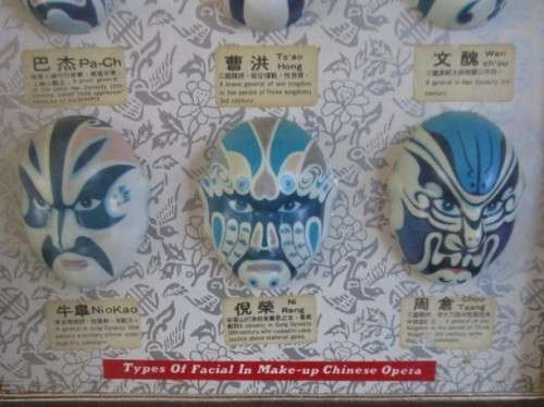 A VINTAGE BOXED FRAME DEPICTING VARIOUS FACIAL MASKS/CHARACTERS IN CHINESE OPERA