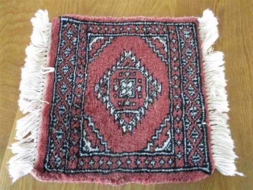 A SET OF FOUR HAND WOVEN PERSIAN PLACE MATS