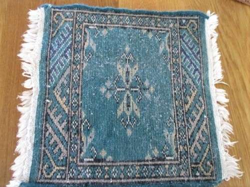 A SET OF FOUR HAND WOVEN PERSIAN PLACE MATS
