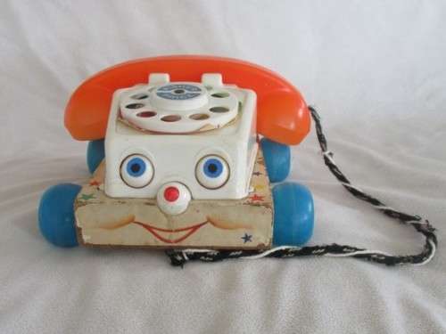 A VINTAGE 1960's FISHER PRICE PULL ALONG TELEPJONE WITH WOODEN BASE