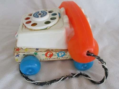 A VINTAGE 1960's FISHER PRICE PULL ALONG TELEPJONE WITH WOODEN BASE