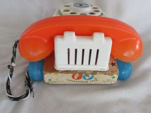 A VINTAGE 1960's FISHER PRICE PULL ALONG TELEPJONE WITH WOODEN BASE