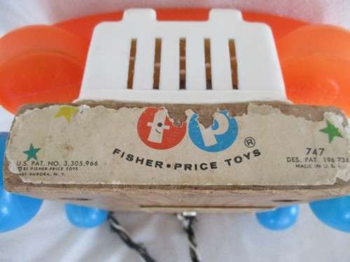 A VINTAGE 1960's FISHER PRICE PULL ALONG TELEPJONE WITH WOODEN BASE
