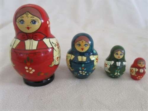 A VINTAGE FOUR PIECE HAND PAINTED MATRYOSHKA/BABUSHKA NESTING DOLL SET - SIGNED