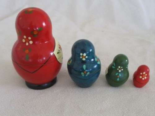 A VINTAGE FOUR PIECE HAND PAINTED MATRYOSHKA/BABUSHKA NESTING DOLL SET - SIGNED