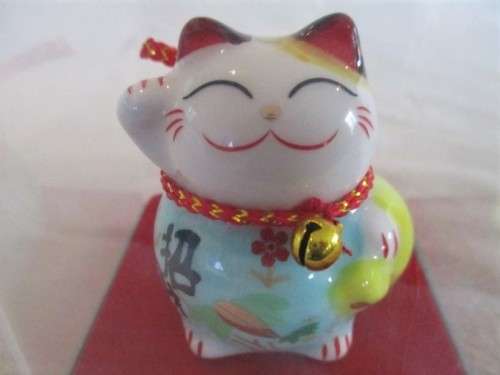A CUTE CHINESE PORCELAIN MANEKI-NEKO (LUCKY CAT) IN PERSPEX BOX