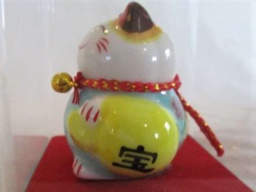 A CUTE CHINESE PORCELAIN MANEKI-NEKO (LUCKY CAT) IN PERSPEX BOX