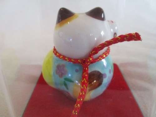 A CUTE CHINESE PORCELAIN MANEKI-NEKO (LUCKY CAT) IN PERSPEX BOX