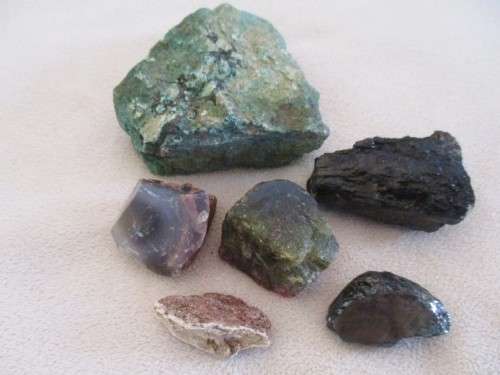 A COLLECTION OF ROUGH GEMSTONE ROCKS, CRYSTALS AND THREE LARGER SIZE TUMBLE STONES