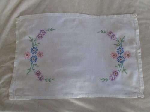 A VINTAGE RECTANGULAR HAND EMBROIDERED CLOTH WITH PRETTY PINK, BLUE AND LAVENDER DAISIES