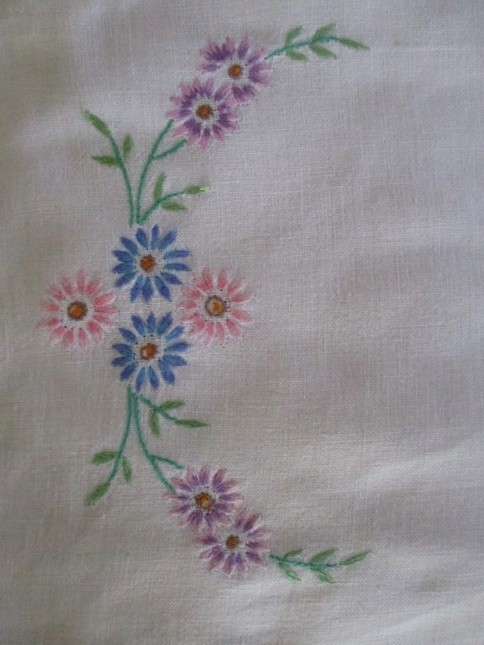 A VINTAGE RECTANGULAR HAND EMBROIDERED CLOTH WITH PRETTY PINK, BLUE AND LAVENDER DAISIES