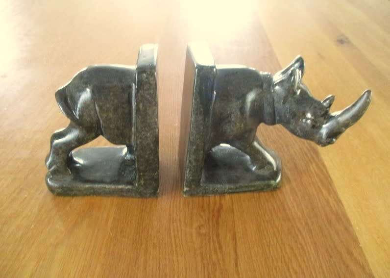 A PAIR OF HEAVY HAND CARVED STONE RHINO BOOK ENDS