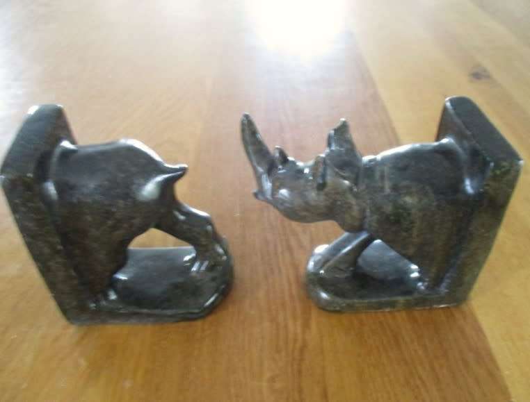 A PAIR OF HEAVY HAND CARVED STONE RHINO BOOK ENDS