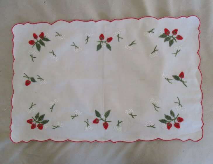 A CHEERFUL EMBROIDERED CLOTH WITH BERRIES AND SCALLOPED BORDER