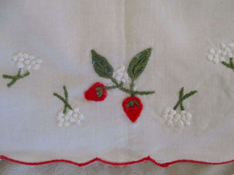 A CHEERFUL EMBROIDERED CLOTH WITH BERRIES AND SCALLOPED BORDER