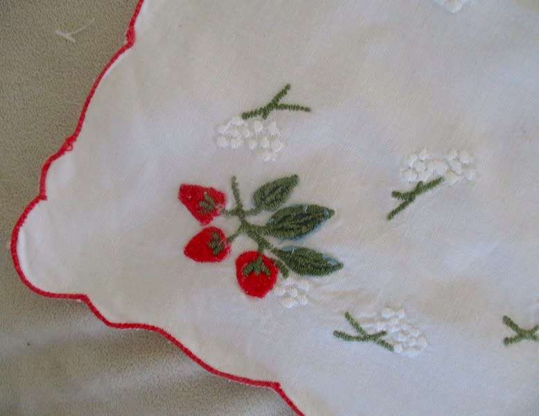 A CHEERFUL EMBROIDERED CLOTH WITH BERRIES AND SCALLOPED BORDER