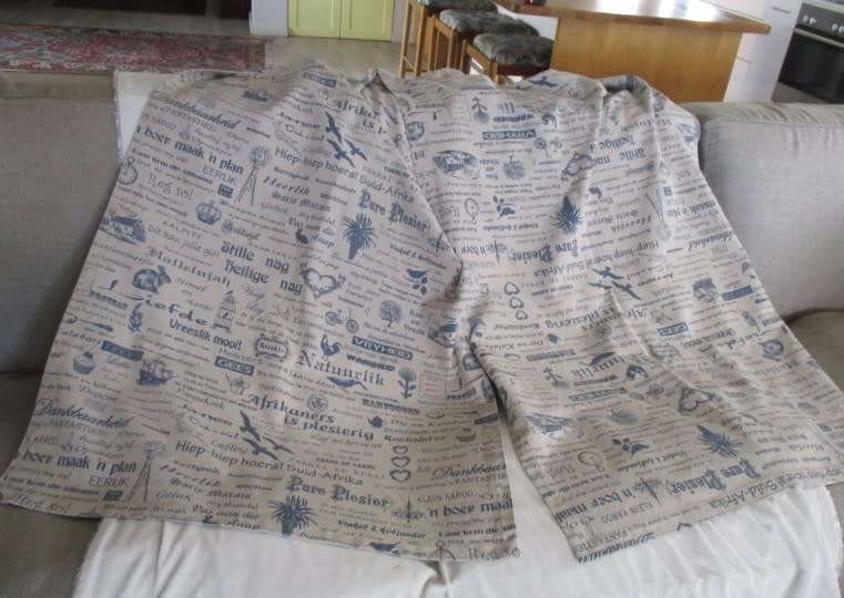 A very large, very long, wide table runner with South African scenes, songs and sayings