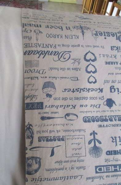 A very large, very long, wide table runner with South African scenes, songs and sayings