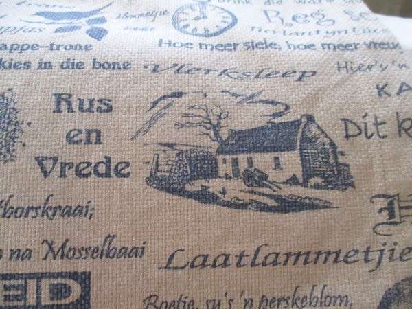 A very large, very long, wide table runner with South African scenes, songs and sayings