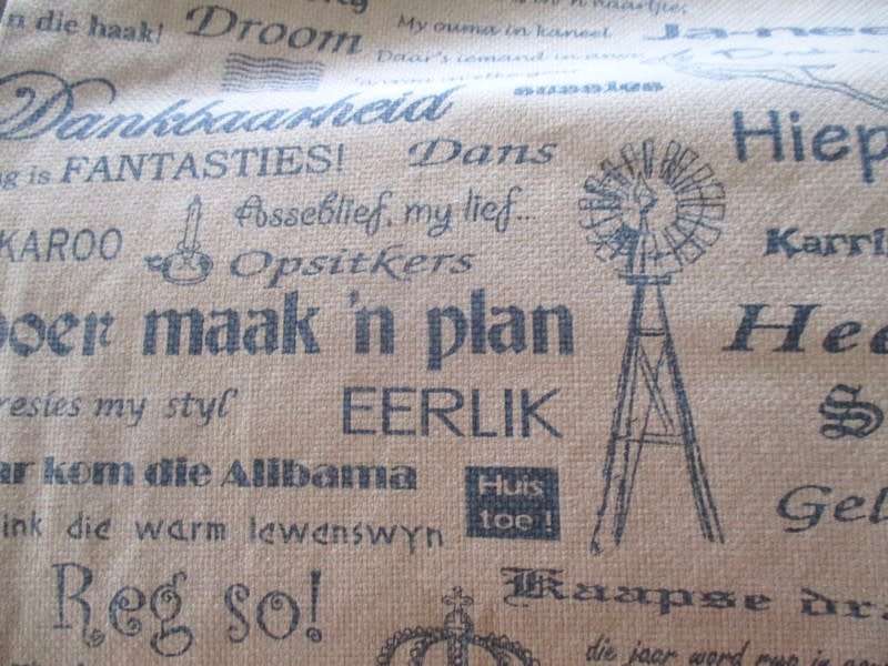 A very large, very long, wide table runner with South African scenes, songs and sayings