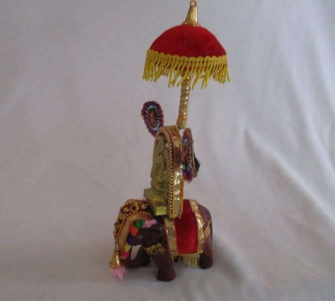 Colourful figurine of Ganesha on hand carved wooden elephant