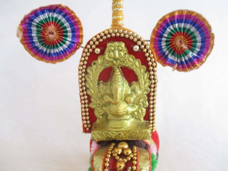 Colourful figurine of Ganesha on hand carved wooden elephant