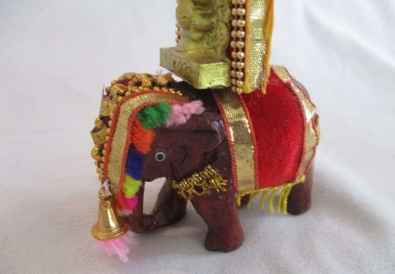 Colourful figurine of Ganesha on hand carved wooden elephant