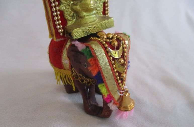 Colourful figurine of Ganesha on hand carved wooden elephant