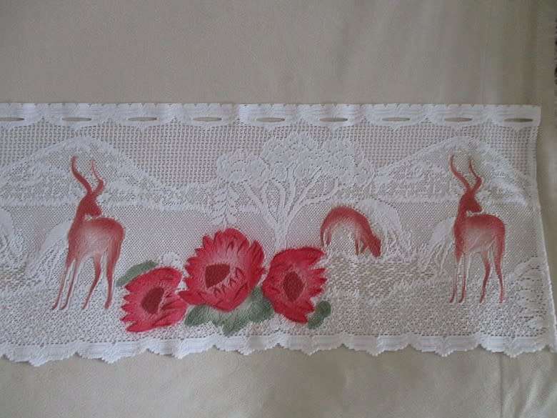 An unusual `half mast` lace curtain with with coloured proteas and animals