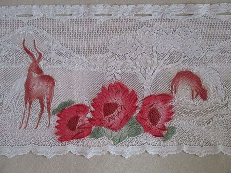An unusual `half mast` lace curtain with with coloured proteas and animals