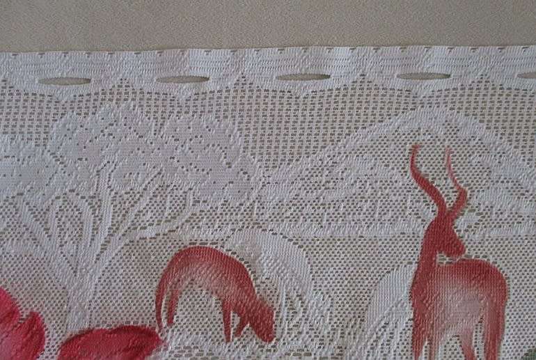 An unusual `half mast` lace curtain with with coloured proteas and animals