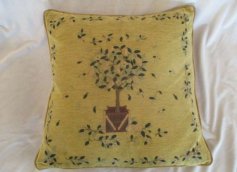 A vintage tapestry-style cushion with potted tree design