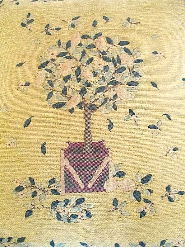 A vintage tapestry-style cushion with potted tree design