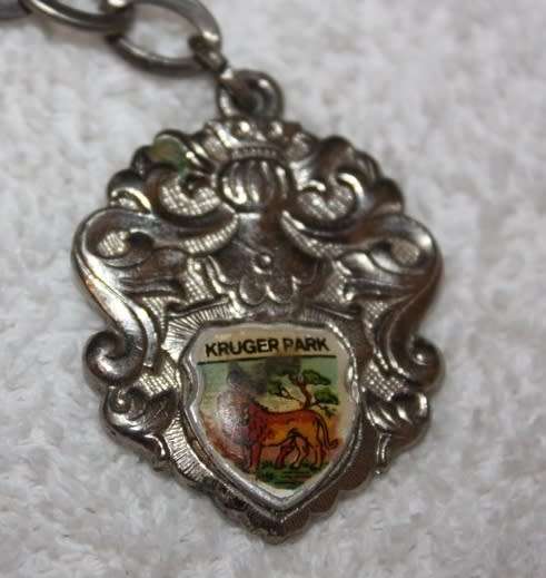 KRUGER NATIONAL PARK SHIELD KEYRING WITH SMALL ENAMEL INSERT DEPICTING A LION