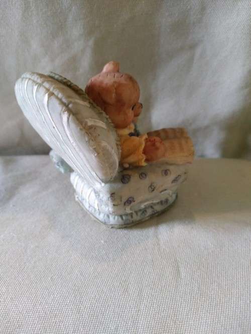 Teddy bear in blue armchair talking on the telephone
