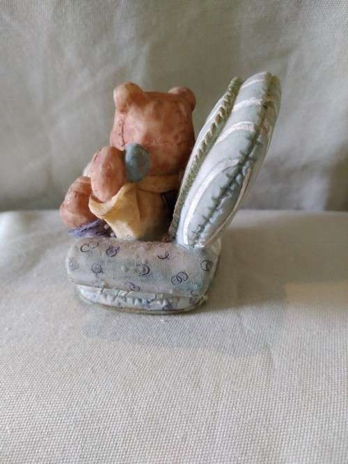 Teddy bear in blue armchair talking on the telephone
