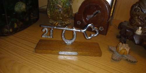 Metal 21st birthday key on wooden plinth