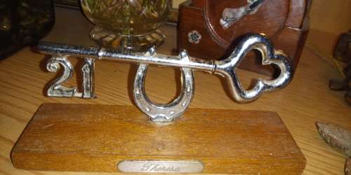 Metal 21st birthday key on wooden plinth