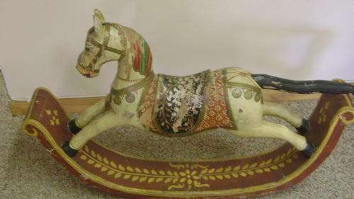 A CARVED AND PAINTED WOODEN ROCKING HORSE - very old