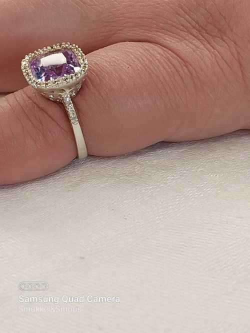 Sterling silver ladies ring with purple violet stone surrounded by cubic zirconia Size: K.5