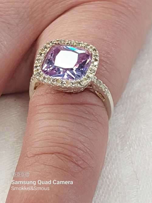 Sterling silver ladies ring with purple violet stone surrounded by cubic zirconia Size: K.5
